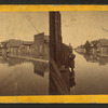 Wooden houses along a flooded Main street.