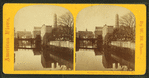 View of buildings lining the banks of an unidentified body of water, possibly Jones Falls.