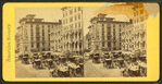Monument square [full of carriages, showing hotels and the monument].