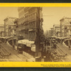 Baltimore street[Street view showing wagons, street car tracks, businesses, signs, awnings].