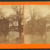 Man stading ankle deep in water on a flooded street.