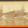 View of man standing on a road damaged by a flood.
