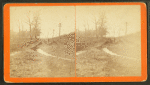 View of man standing on a road damaged by a flood.