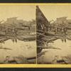 Debris piled around bulkheads of a bridge apparently destroyed in a flood.