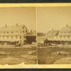 View of a large house with buggies and horses.