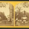 Civil war mounument in Clinton, decorated with garlands, 2 girls sitting on fence in foreground.