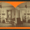 View of parlor in Upton, baby carriage visible through a door.