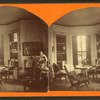 Parlor in Upton, looking toward shuttered bay window, chairs, table, and statuette visible.