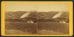 View of a valley with trees, houses and a plume of smoke(?).
