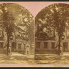 Decorations for a centennial celebration with an arch reading "1778 Welcome 1878" near a building decorated with banners.