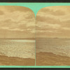 View of the ocean with a ship in the distance.