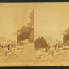 People standing on a rocky shore.