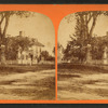 View of large home surrounded by a picket fence.