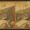 Women standing on a hill side hear a brook.