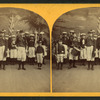 Group of boys in military costume, holding rifles, flags and a drum.