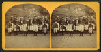 Group of boys in military costume, holding rifles, flags and a drum.