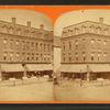 View of a commercial block, stores on street level, sign for Enterprise printing works.