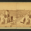 Group on a beach, some with umbrellas.
