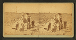Group on a beach, some with umbrellas.
