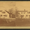 Unidentified home at a cross roads surrounded by a picket fence.