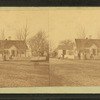 Unidentified home at a cross roads surrounded by a picket fence.