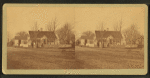 Unidentified home at a cross roads surrounded by a picket fence.