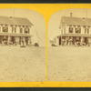 Group of people on the porch of a house emblazzed with the words "Our House".