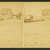 Men standing near boats on the beach, Our House in the background.