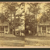 View of a cottage, trees in front, people on porch.