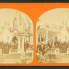 People in front of a cottage decorated with bunting.