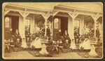 Group posing on the porch of a cottage.