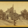 View of a street with a few people standing in it.