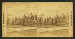 People in and gathered around a wagon.