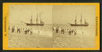People on the shore looking at a ship.