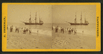 People on the shore looking at a ship.