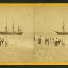People on the shore looking at a ship.