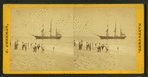 People on the shore looking at a ship.