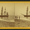 People on the shore looking at a ship.