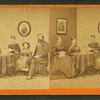 Studio portrait of family, stereo-viewer on table, one girl with book.