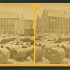 Barrels in front of a large building.