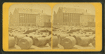 Barrels in front of a large building.