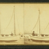 [A couple and their ketch-rigged sailboat, on dry land.]
