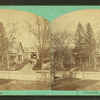 View of a large house, white picket fence in foreground.