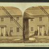 People standing in front of their house, Chain Bridge toll house at left.