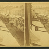 Street thronged with buggy and wagon traffic.