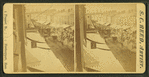 Street thronged with buggy and wagon traffic.