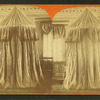 View of an interior with an unidentified drape-enclosed structure.