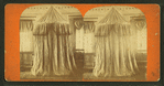 View of an interior with an unidentified drape-enclosed structure.