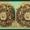 View of a photographic portrait surrounded by a memorial wreath.