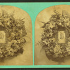 View of a photographic portrait surrounded by a memorial wreath.